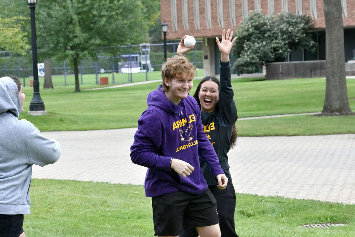 A male and female student laugh during the Lawnsay games